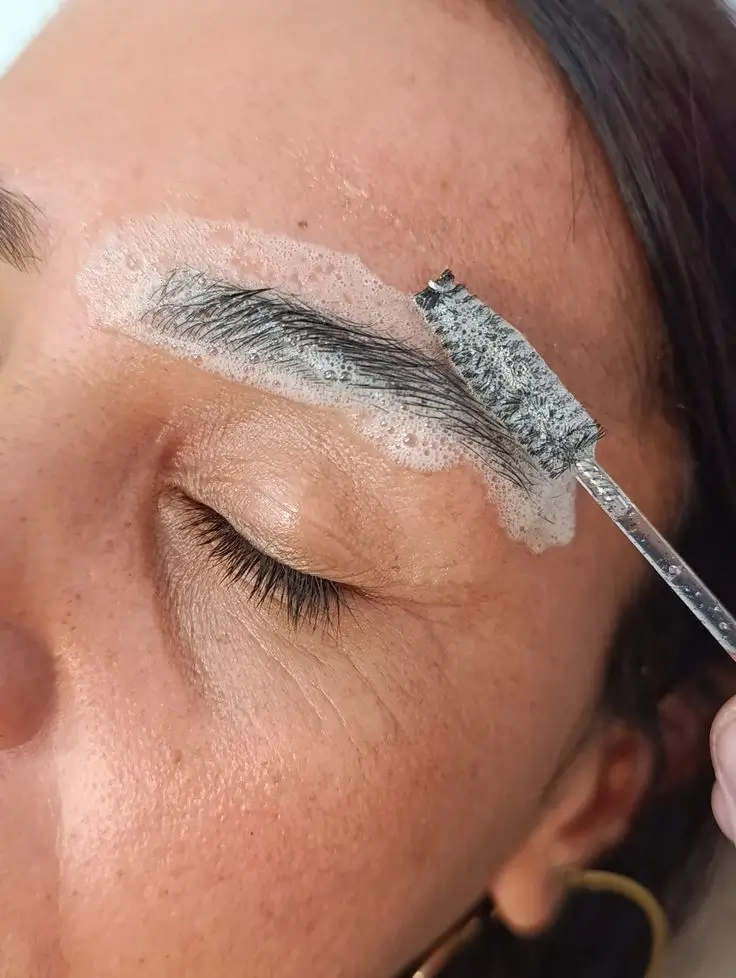 Kit de higienização para design de sobrancelhas, incluindo algodão, gel calmante e outros produtos de limpeza.
